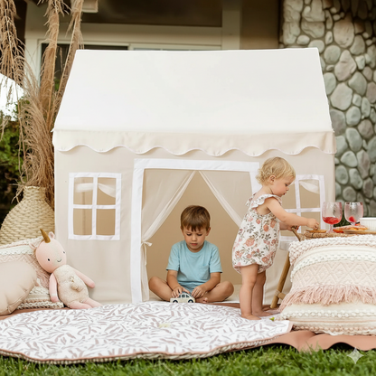 Children playing inside a white play tent in an outdoor setting.