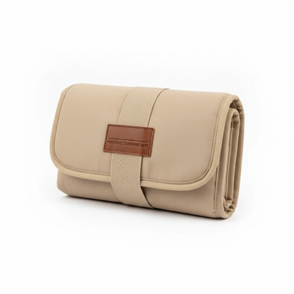 Beige portable changing mat with brown leather patch on a white background